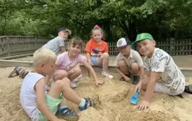 Sześcioro dzieci bawi się w piaskownicy