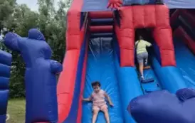Dziewczynka zjeżdża z dmuchanej zjeżdżalni