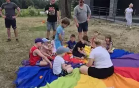 Dzieci siedzą na kolorowej chuście