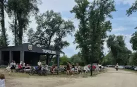 Uczestnicy pikniku siedzą na ławeczkach przy scenie w Topolinie w Mielniku