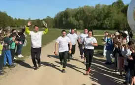 Grupa os&oacute;b biegnie pomiędzy dziećmi bijącymi brawa