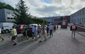 Grupa os&oacute;b wychodzi ze szkoły