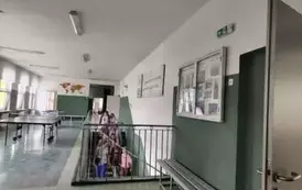Grupa uczni&oacute;w schodzi na parter w budynku szkoły