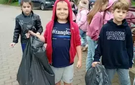 Uczniowie klasy pierwszej trzymają worki