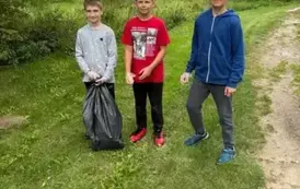Trzech uczni&oacute;w pozuje do zdjęcia podczas akcji Sprzątanie Świata