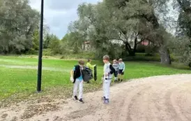 Chłopcy trzymają worki i sprzątaja teren