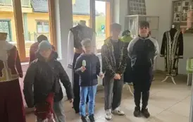 Uczniowie pozują ne tle stroj&oacute;w tatarskich