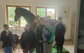 Uczniowie pozują na tle figury konia