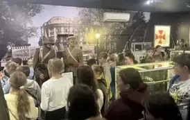 Uczestnicy wycieczki oglądają mundury żołnierzy w Muzeum Wojska