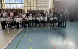 Uczniowie klasy pierwszej wraz z rodzicami i dyrektorem szkoły pozują do zdjęcia