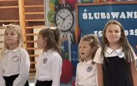 Dziewczynki ubrane na galowo śpiewają
