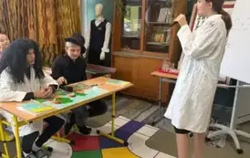 Uczniowie podczas scenki przedstawiającej lekcję chemii