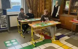Uczniowie klasy &oacute;smej w ławkach szkolnych