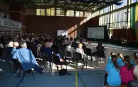 Zgromadzeni goście oglądają film o szkole