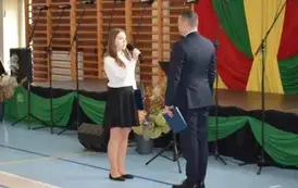 Uczennica składa meldunek dla dyrektora szkoły
