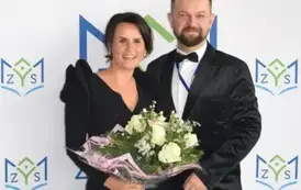 Prowadząca wraz z solistą pozują naa ściance
