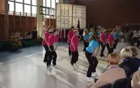 Grupa uczennic w kolorowcy koszulkach taańczy podczas występu