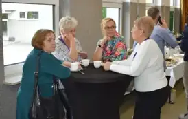 Absolwenci wraz z nauczyielem rozmawiają na korytarzach szkolnych