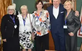 Absolwenci szkoły z uśmiechem pozują do zdjęcia