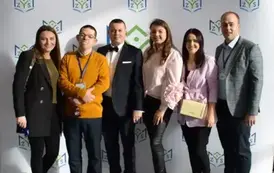 Absolwenci szkoły wraz z dyrektorem szkołypozują na ściance
