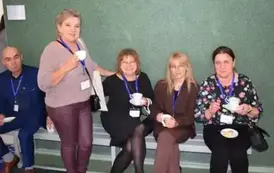 Absolwenci siedza na ławce i pozują do zdjęcia