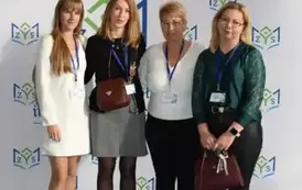 Absolwenci i nauczyciel pozują do zdjęcia