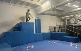Uczeń skacze z wysokości na materace w parku trampolin