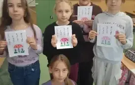 Stojące uczennice trzymają swoje karty pracy