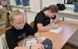 Uczennice z klasy piątej rozwiązują zadania matematyczne