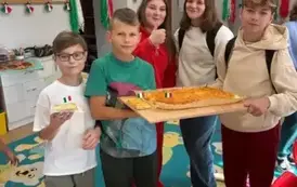 Dziewczynki i chłopcy trzymają pizzę