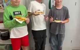Chłopcy z klasy czwartej jedzą pizzę