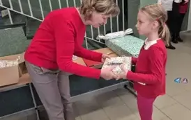 Uczennica klasy trzciej otrzymuje nagrodę w konkursie plastycznym