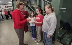 Trzy dziewczynki otrzymują nagrody za udział w konursie literackim