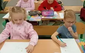 Dziewczynki z klasy pierwszej w ławkach szkolnych