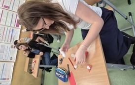 Dziewczynka w sali matematycznej składa Mikołaja metodą origami