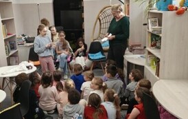 Grupa uczni&oacute;w w bibliotece szkolnej podczas zajęć