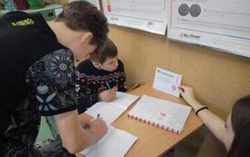 Uczniowie siedzą w ławce i wykonują zadania z karty pracy