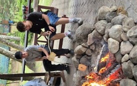 Chłopcy pieką chleb na ognisku