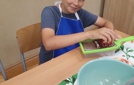 Chłopiec ściera jabłko na sałatkę.jpeg