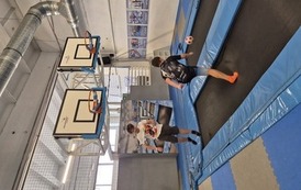 Dw&oacute;ch chłopc&oacute;w podczas gry w koszyk&oacute;wkę na trampolinach
