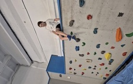 Dziewczynka w sportowym stroju na ściance wspinaczkowej
