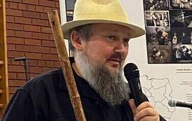 Mężczyzna z brodą m&oacute;wi do mikrofonu