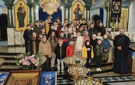 Grupa-uczni&oacute;w-z-osobą-duchowną-na-tle-ikon-w-cerkwi