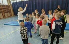 Grupa dzieci stoi dookoła nauczycielki