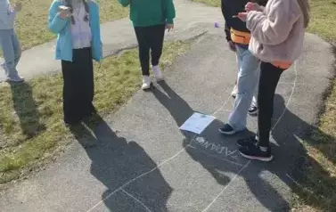 Uczniowie stojący na planszy gry matematycznej