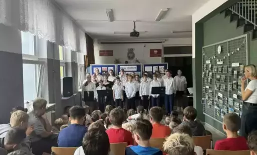 uczniowie w strojach galowych występują podczas akademii 